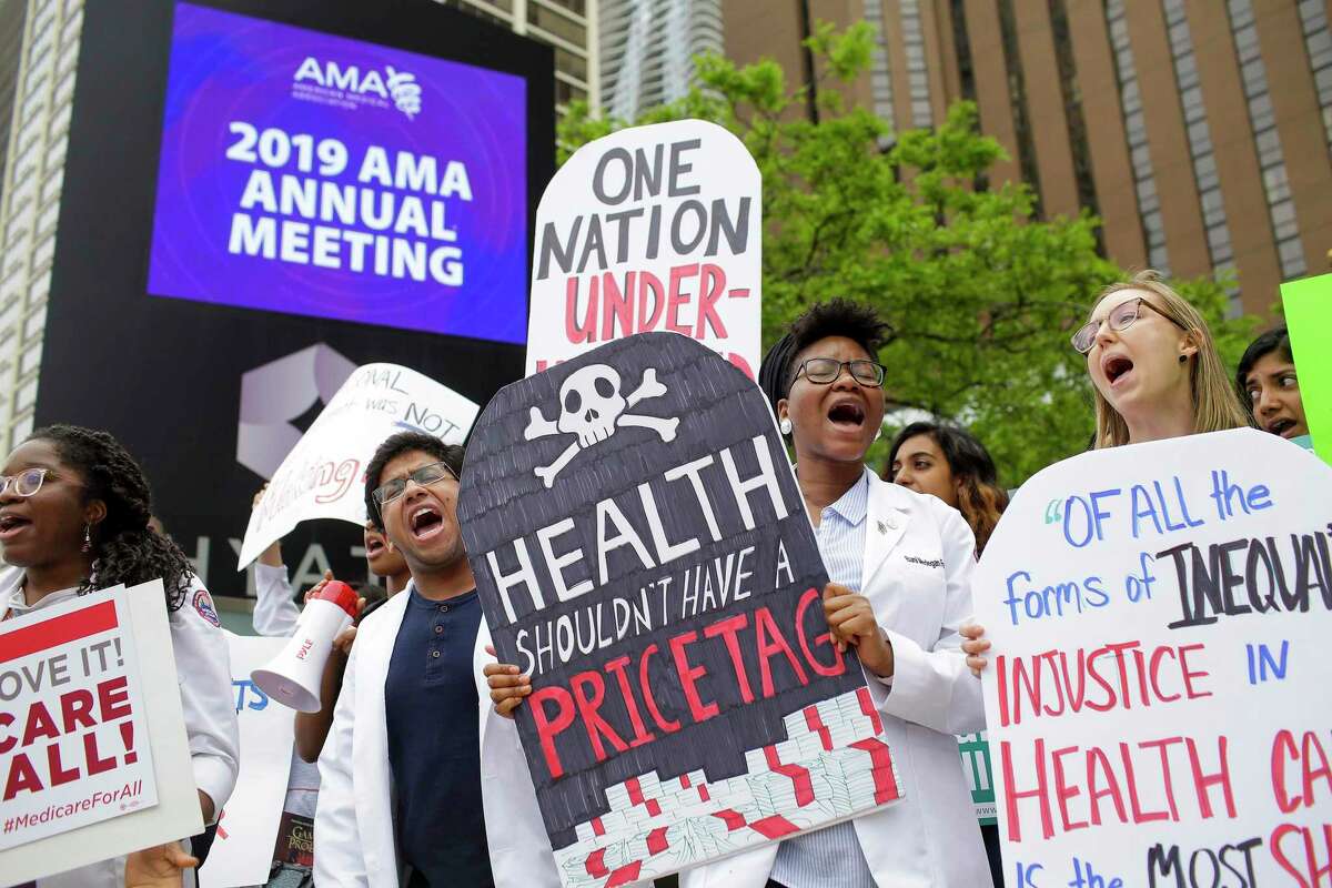 Medical students demonstrating in favor of Medicare for All hold protest signs at a rally outside a hotel where the American Medical Association was holding its annual meeting in Chicago. Health spending in the United States rose by 4.6 percent to $3.6 trillion in 2018 — accounting for 17.7 percent of the economy — compared to a growth rate of 4.2 percent in 2017. (Joshua Lott/The New York Times)