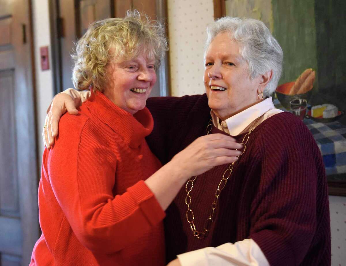 Cathy Ostuw, left, co-founder of Building One Community, hugs her friend Mary Maarbjerg after being surprised to learn that she is this year's Stamford Citizen of the Year winner on Thursday, Dec. 12, 2019. Ostuw was heading to her weekly Scrabble game with friends when Mayor David Martin and dozens of friends and colleagues suprised her with the honor, which is sponsored by Post 142 of the Jewish War Veterans of the United States. Building One Community's mission is to advance the successful integration of immigrants and their families.