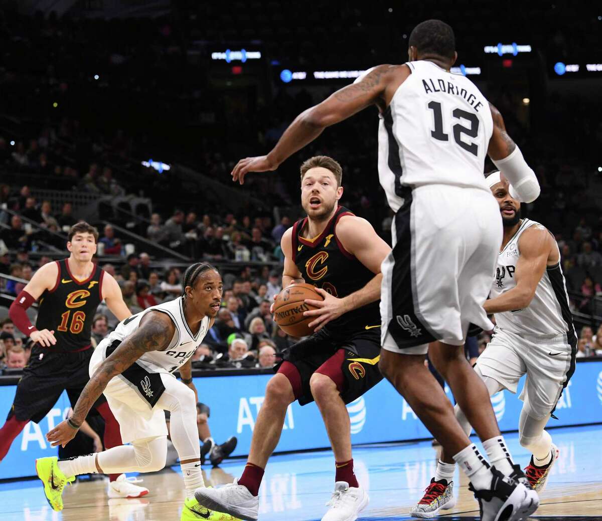 Matthew Dellavedova of the Cleveland Cavaliers drives to the basket as DeMar DeRozan left, LaMarcus Aldridge (12) and Patty Mills, right, of the San Antonio Spurs defend during NBA action in the AT&T Center on Thursday, Dec. 12, 2019.