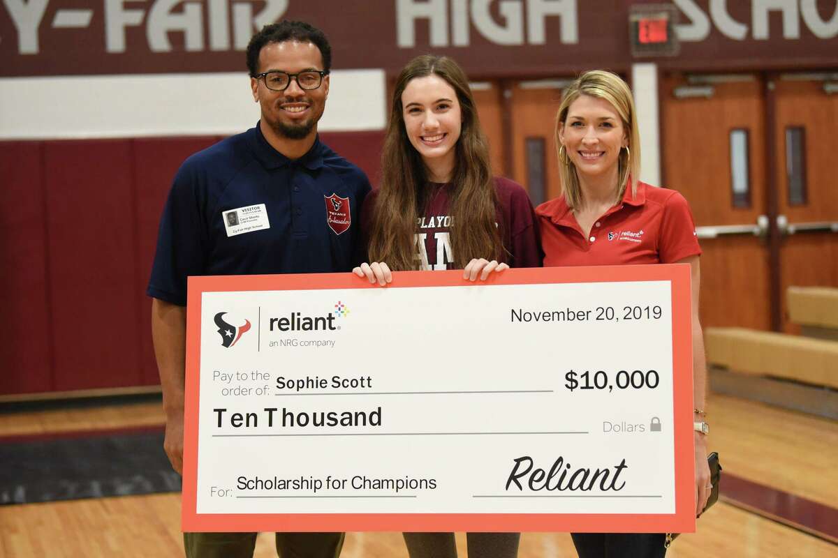 Sophie Scott (center), a senior at Cy-Fair High School, is awarded a $10,000 scholarship by Cecil Shorts (left) who was a wide receiver on the Houston Texans, and Katie Register (right) with Reliant Energy. Scott was announced as a winner of the Scholarship for Champions program during a pep rally on Nov. 20, 2019.