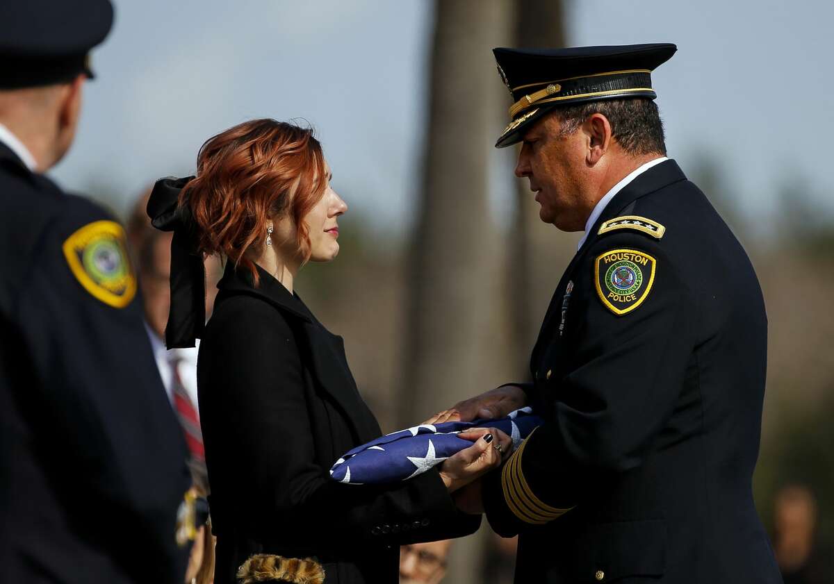 Houston Police Chief Art Acevedo presents a flag to Houston Police Sgt. Christopher Brewster's widow, Bethany Elise Brewster, during a funeral service Thursday, Dec. 12, 2019, at Grace Church Houston in Houston. Brewster, 32, was gunned down Saturday evening, Dec. 7, while responding to a domestic violence call in Magnolia Park. Police arrested 25-year-old Arturo Solis that night in the shooting death. Solis faces capital murder charges. (Godofredo A. Vasquez/Houston Chronicle via AP)