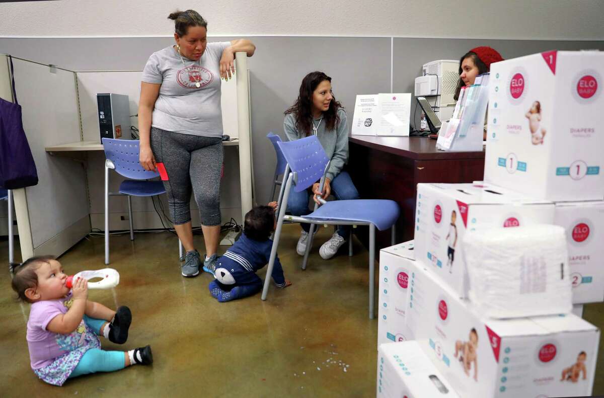 Monse Delgado, center, picks up diapers for her 1-year-old, Joe Yohander, as Lupita Mendoza waits with her 1-year-old, Jimena Sarci Rivas, at the child care resource desk of the SF Human Services Agency on Nov. 22, 2019, in San Francisco. Research shows that the financial scarcity focuses the mind. But that increased focus comes at a cost. By tunneling our vision on some things, we lose the ability to deal rationally with others.