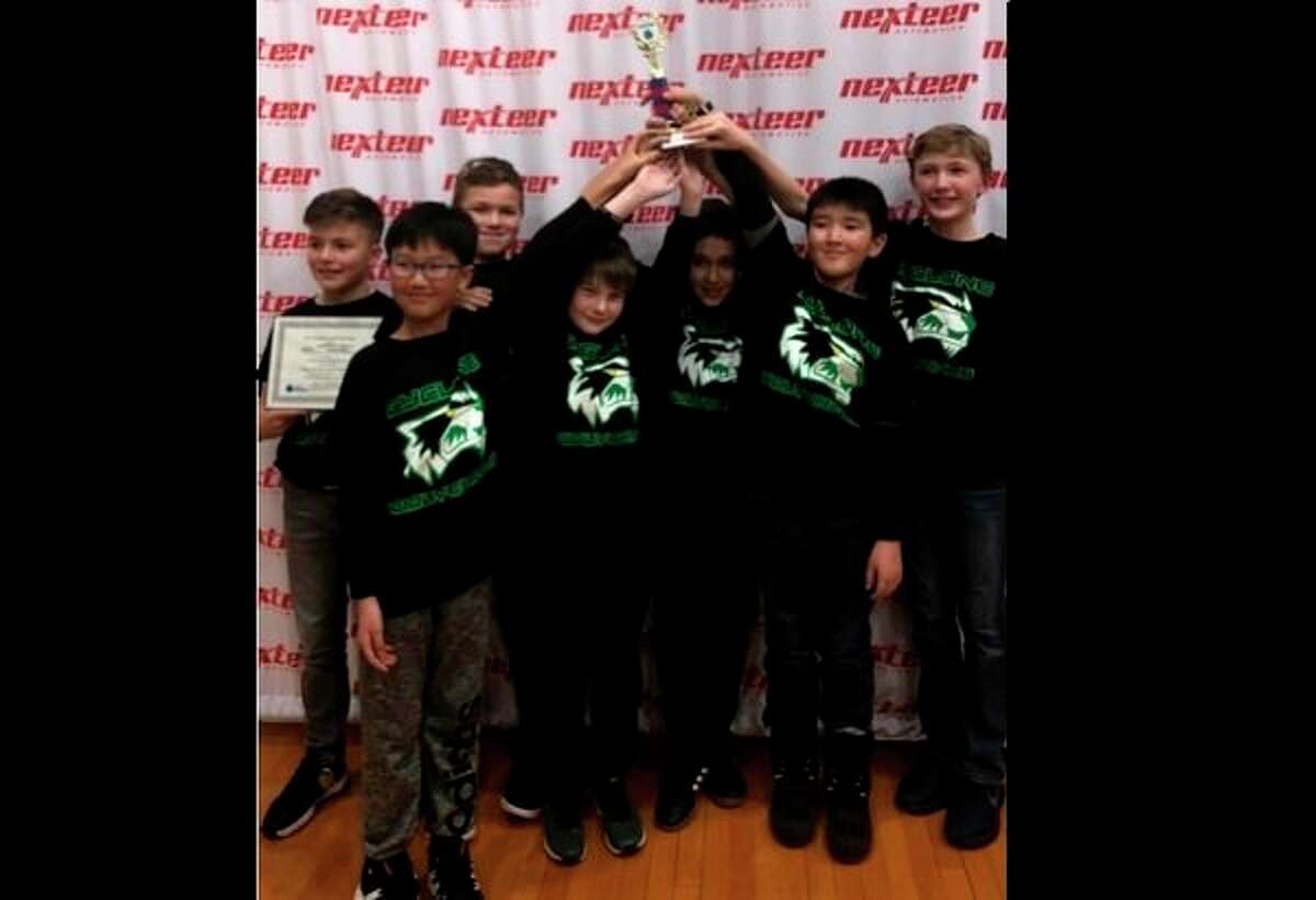 The Woodcrest Cyclone Wolverines, a robotics team made of seven fifth-grade boys, pose with their trophy. (Photo provided)