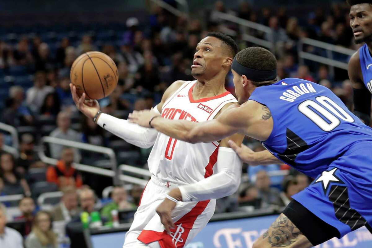 Houston Rockets' Russell Westbrook, left, goes to the basket past Orlando Magic forward Aaron Gordon (00) during the first half of an NBA basketball game, Friday, Dec. 13, 2019, in Orlando, Fla. (AP Photo/John Raoux)
