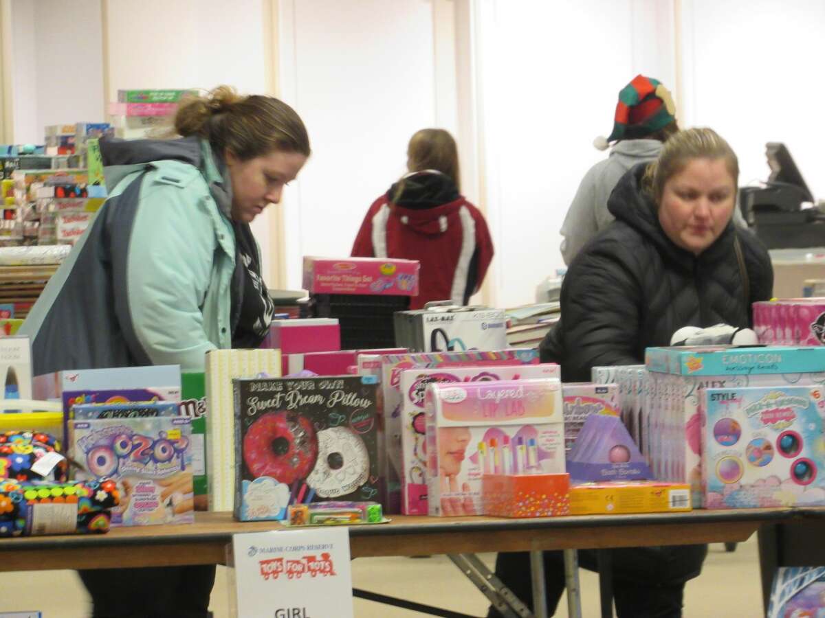 Individuals, with the help of local volunteers, shop for toys at the annual Toys for Tots distribution event on Saturday, Dec. 14 at the Midland Mall.