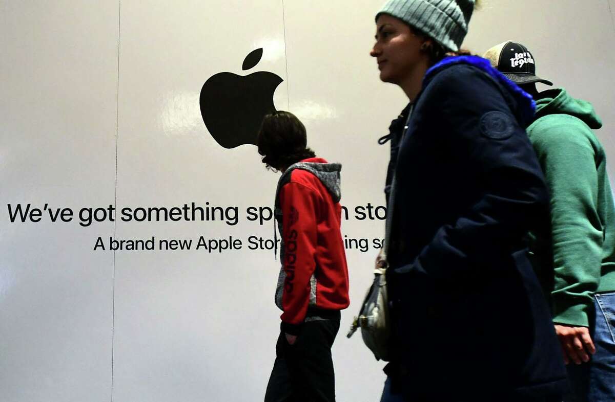 Shoppers walk past the sign heralding the arrival of the Apple store in the new SoNo Collection mall Saturday, December 14, 2019, in Norwalk, Conn.