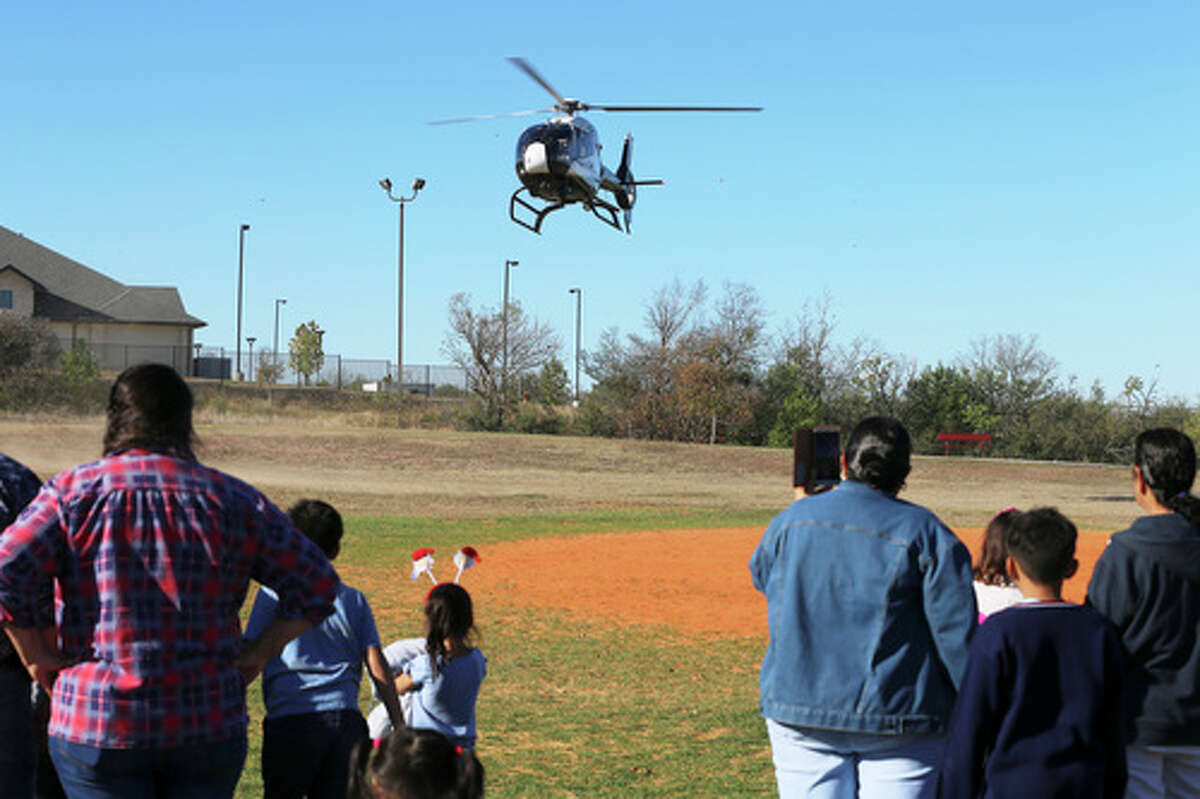 SAPD's Blue Eagle helicopter makes a landing on a softball field as Southside residents celebrate the holidays with Blue Santa at a gathering at Miller's Pond Park on Saturday, Dec. 14, 2019. The event included entertainment, music, food booths and vendors. This is the 19th year for the event that includes a parade and toy give away hosted by the Blue Santa Program, a nonprofit organization created by the San Antonio Police Department. The highlight of the day was when boys and girls went down a basketball court length row of over 2,000 toys of which they could pick one gift for themselves. The program gets their toys from local toy drives, sponsors and vendors of the annual celebration.