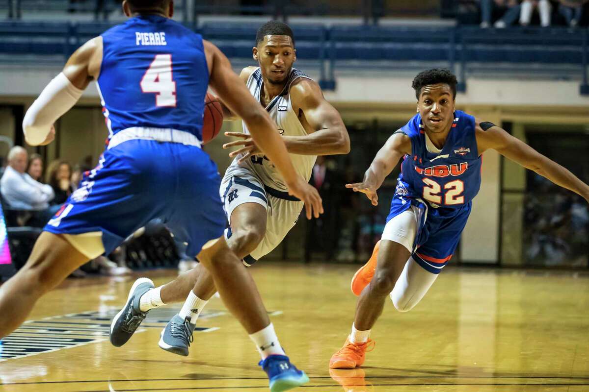 Rice guard Chris Mullins (24) dribbles past Houston Baptist guard Jason Gates (22) and Myles Pierre (4) in the first half of a college basketball game Saturday, Dec 14, 2019, in Houston.