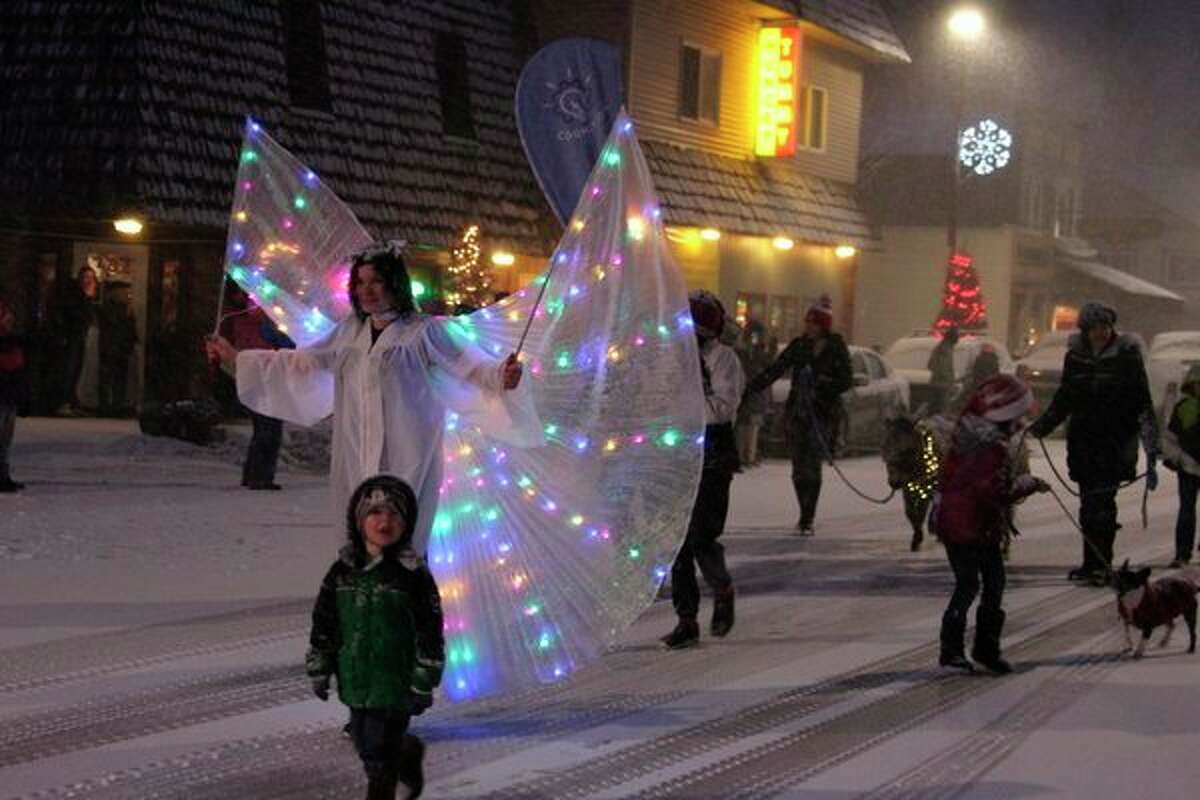 An angel lights the way for the rest of the Cognition entry to the Christmas Magic Parade, which included several donkeys. (Photo/Colin Merry)