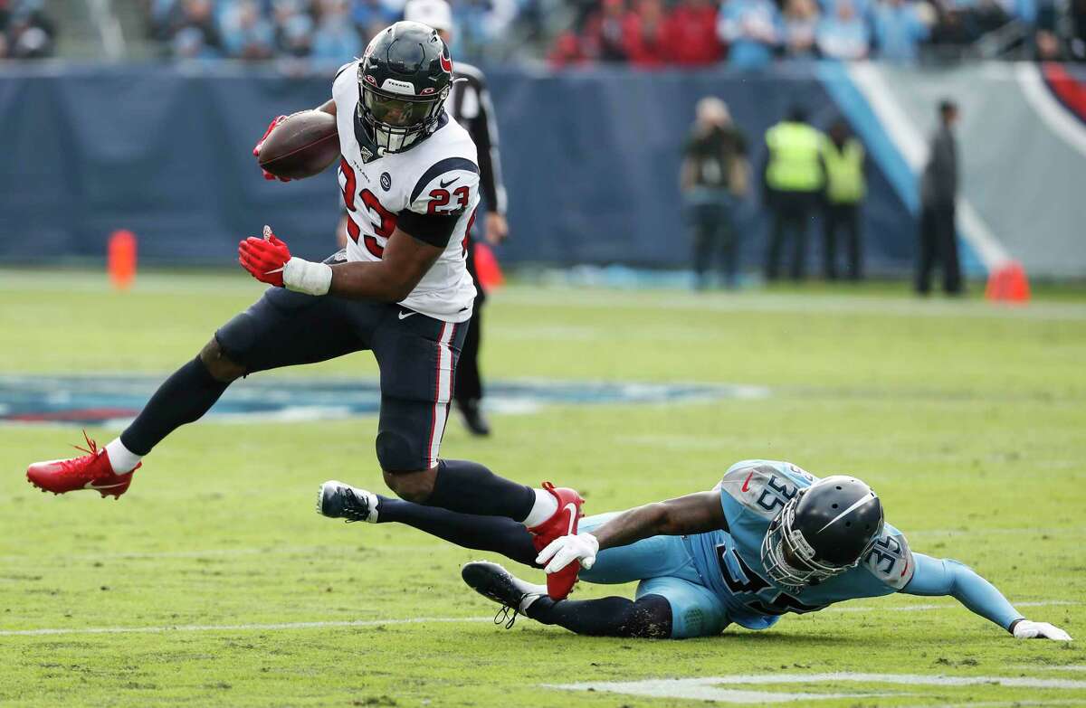 Houston Texans running back Carlos Hyde (23) leaps over Tennessee Titans defensive back Tramaine Brock (35) during the first quarter of an NFL football game at Nissan Stadium on Sunday, Dec. 15, 2019, in Nashville.