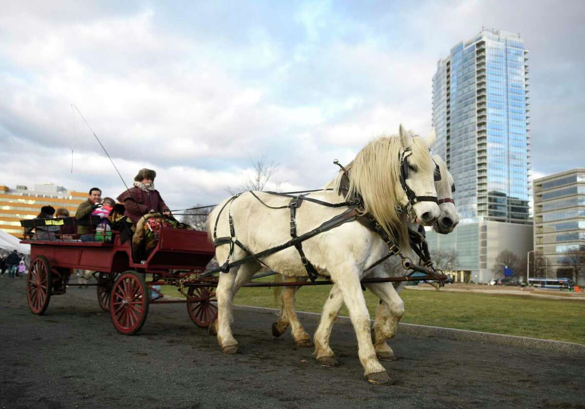 A horse-drawn carriage rides through Mill River Park in Stamford, Conn. Sunday, Dec. 15, 2019. Horse-drawn carriage rides were given at Mill River Park on Sunday, along with skating at the Steven and Alexandra Cohen Skating Center and beer tasting at the Half Full Winter Beer Garden.