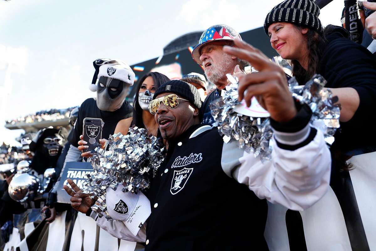 Oakland Raiders' fan MC Hammer poses with Black Hole members before Raiders' final game at Oakland Coliseum in Oakland, Calif., on Sunday, December 15, 2019.