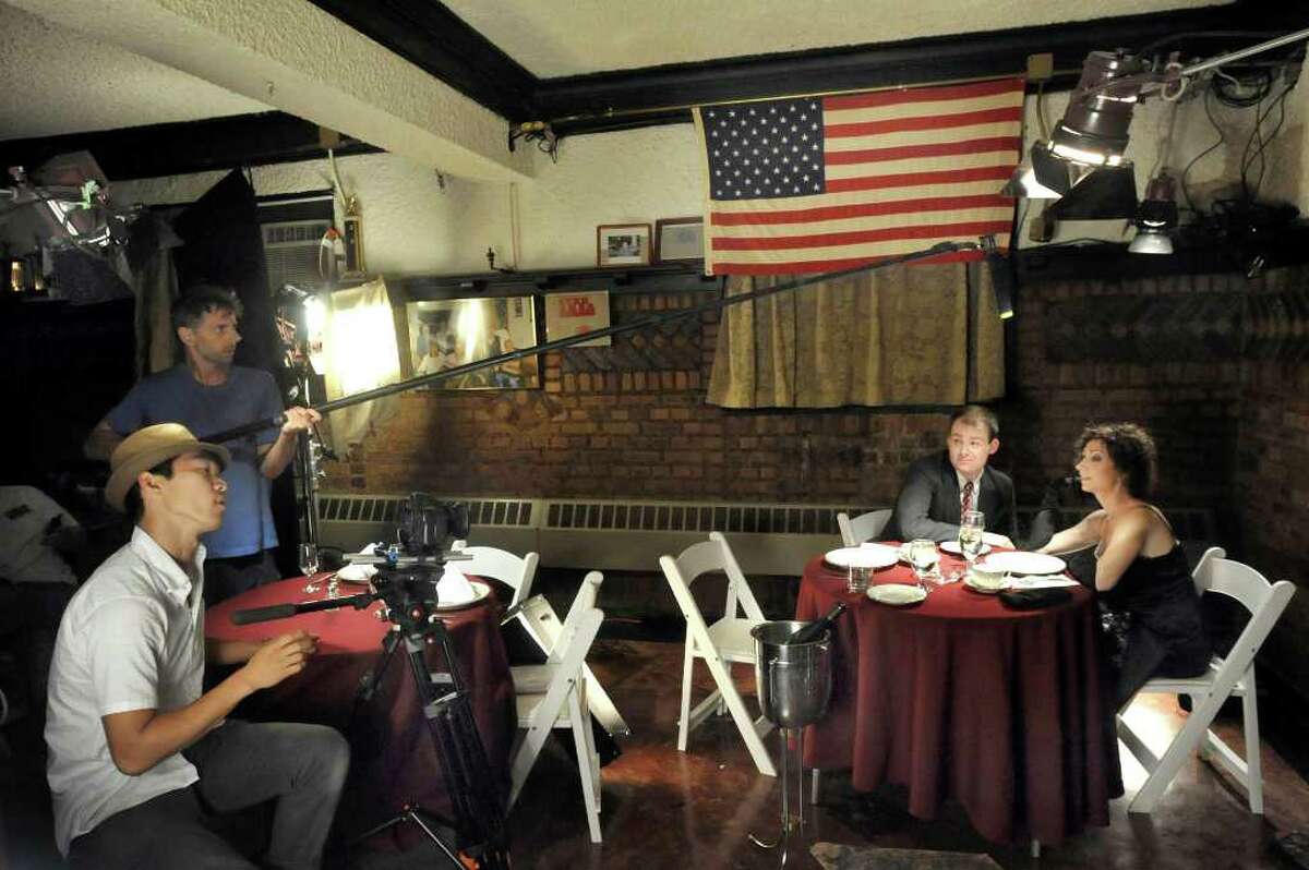 Sung Rae Cho, director of photography, front left, directs actors Pat White and Elise Rovinsky, right, while sound engineer Nick Rosa holds a boom, rear left, during filming of "The Reluctant Detective," in Danbury, Wednesday, Aug. 11, 2010. The film is produced by Erik Tonner of Danbury and Mariette Lange of Stratford.