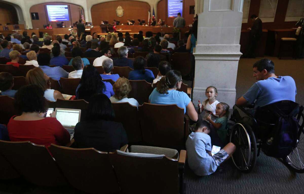 A family attends a San Antonio City Council meeting in 2013. Parents who want to participate in city meetings often have to drag their kids along or skip it altogether. The city is considering free childcare to encourage participation.