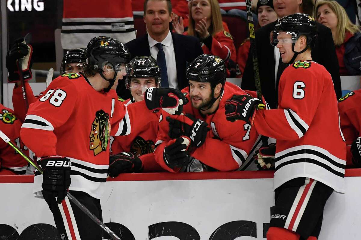 Chicago Blackhawks' Patrick Kane (88) celebrates with teammate Brent Seabrook (7) on the bench after scoring a goal during the first period of an NHL hockey game against the Minnesota Wild, Sunday, Dec. 15, 2019, in Chicago. (AP Photo/Paul Beaty)
