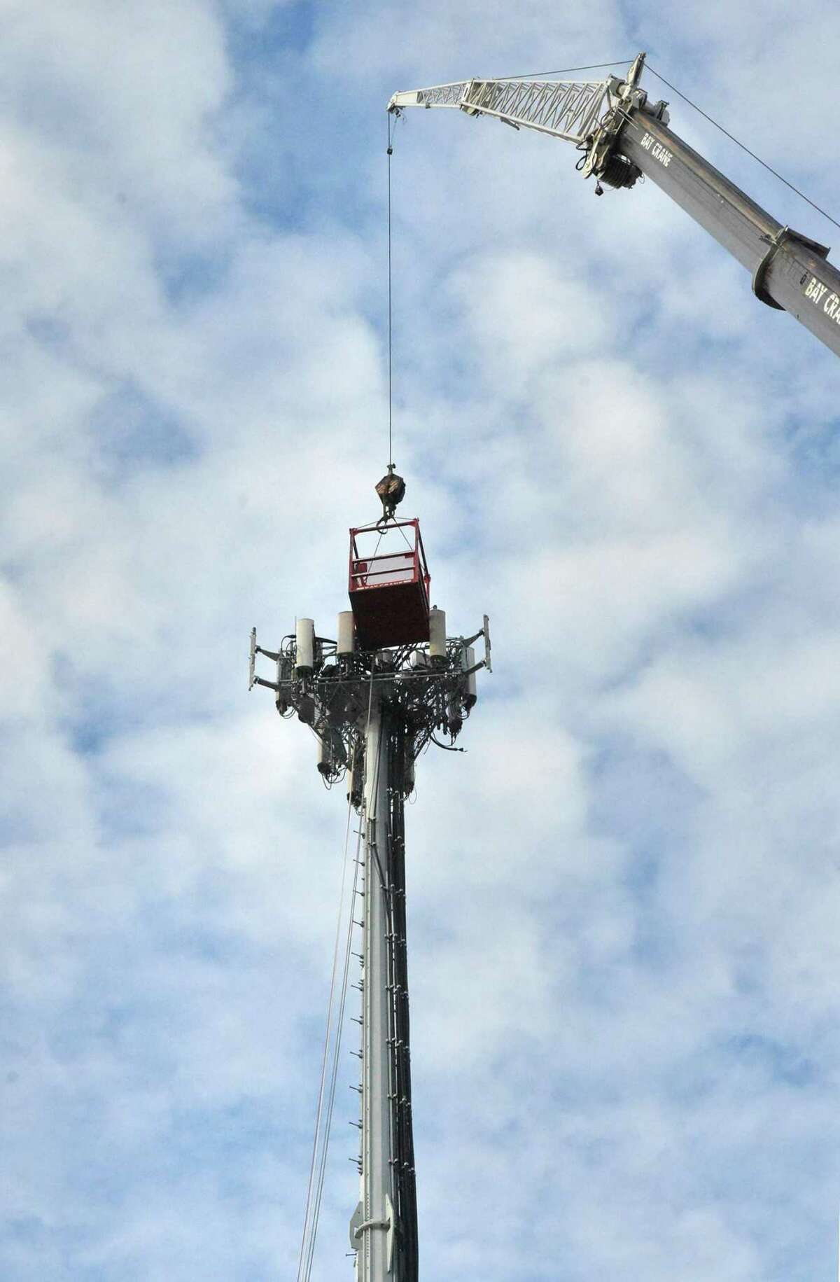 Workers access a cell tower with a crane in Norwalk, Conn., in 2016.