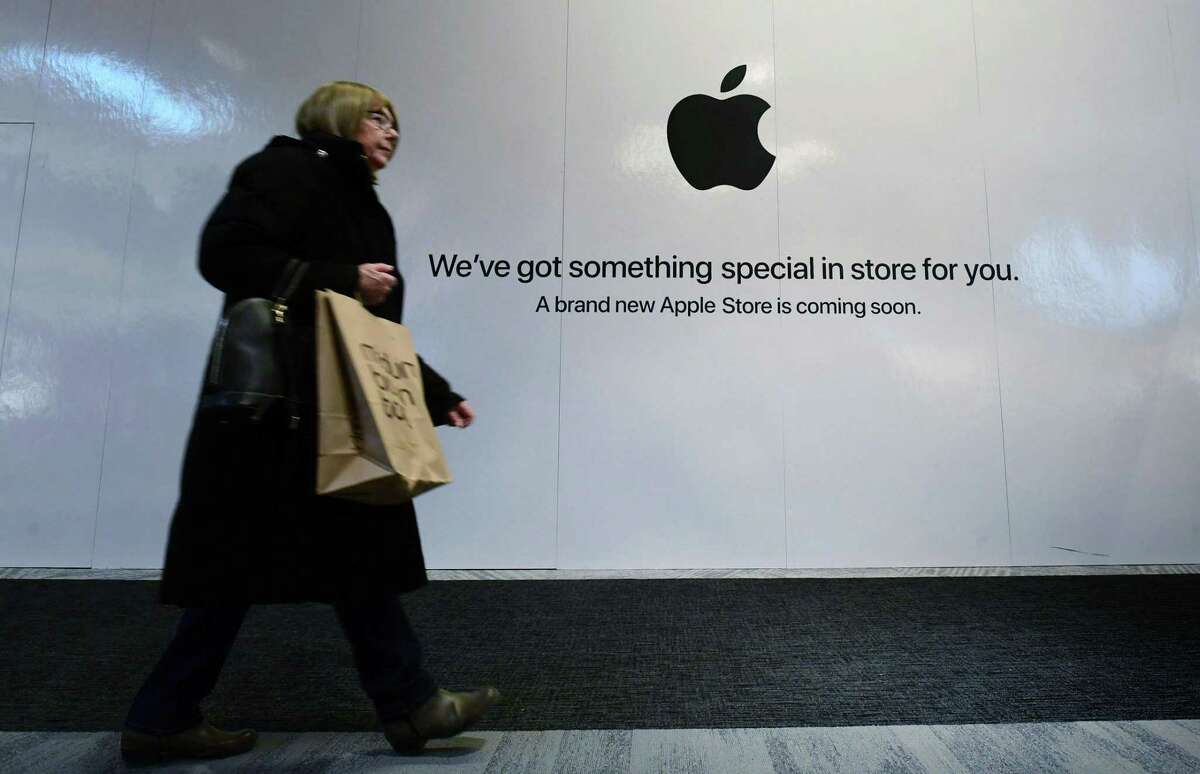 Shoppers walk past the sign heralding the arrival of the Apple store in the new SoNo Collection mall Saturday, December 14, 2019, in Norwalk, Conn.