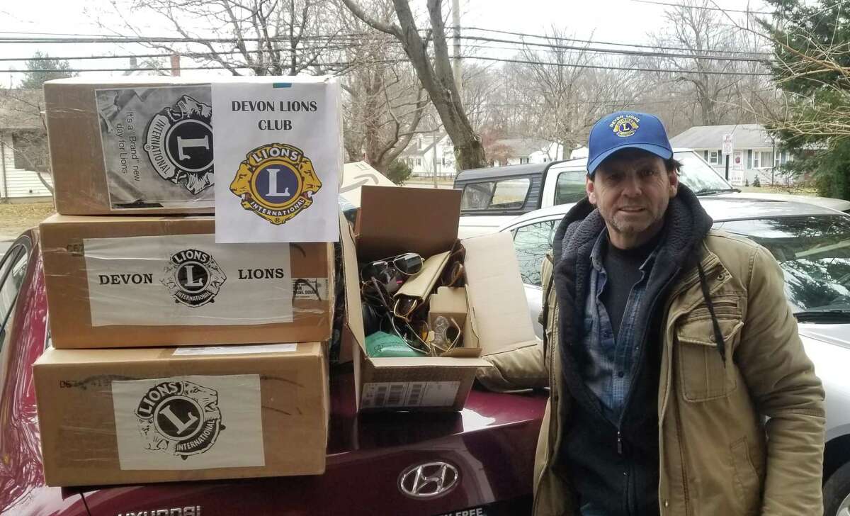 Tom Dowin stands with boxes of eyeglasses to be donated to third world countries.