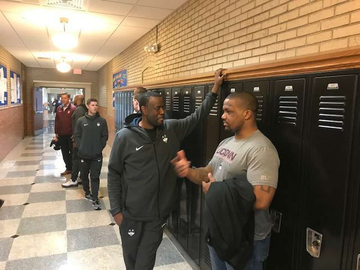 Former Ohio State star running back Maurice Clarett (right), talking with UConn assistant coach Kenya Hunter, has been a frequent mentor and voice of support for the UConn men's basketball team this season.