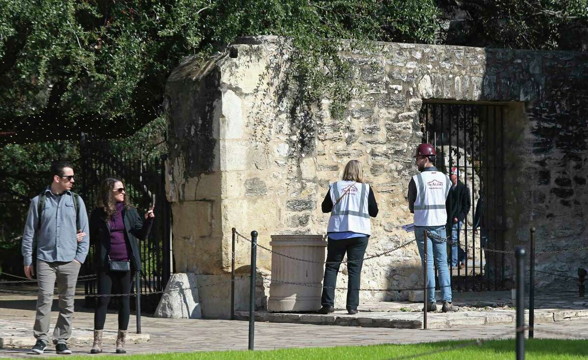 Members of an archaeological crew survey an outside wall at the Alamo on Monday, Dec. 16, 2019. Work has been ongoing for more than a year to install moisture-monitoring equipment in the 1700s mission church and to locate and document its foundations. A work crew recently discovered the skeletal remains of an infant and an adult in the nave of the church and of a teen or young adult in a side room known as the Monk’s Burial Room, which has temporarily halted work in that area.