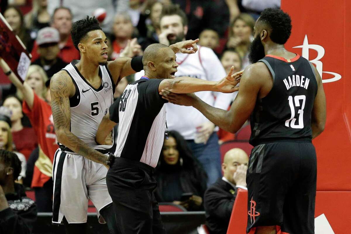Referee Michael Smith, center, separates San Antonio Spurs guard Dejounte Murray (5) and Houston Rockets guard James Harden during the first half of an NBA game Monday, Dec. 16, 2019, in Houston.