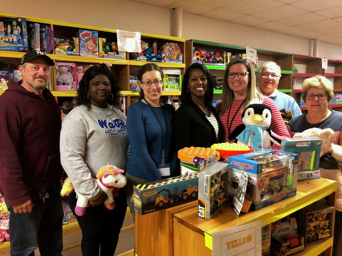 TEAM, Inc. Director of Early Childhood Jamie Peterson, fifth from left, and TEAM Development and Community Manager Lisa Savoie, fourth from left, with volunteers at the organization's Toys 4 Kids toy store.
