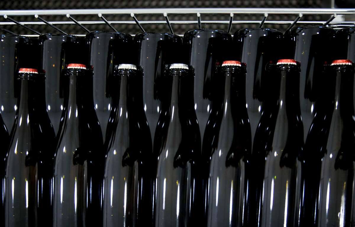 Bottles of sparkling wine wait to be labeled as they sit at the Carboniste barrel space inside RD Winery in Napa, Calif. Saturday, Dec. 14, 2019.