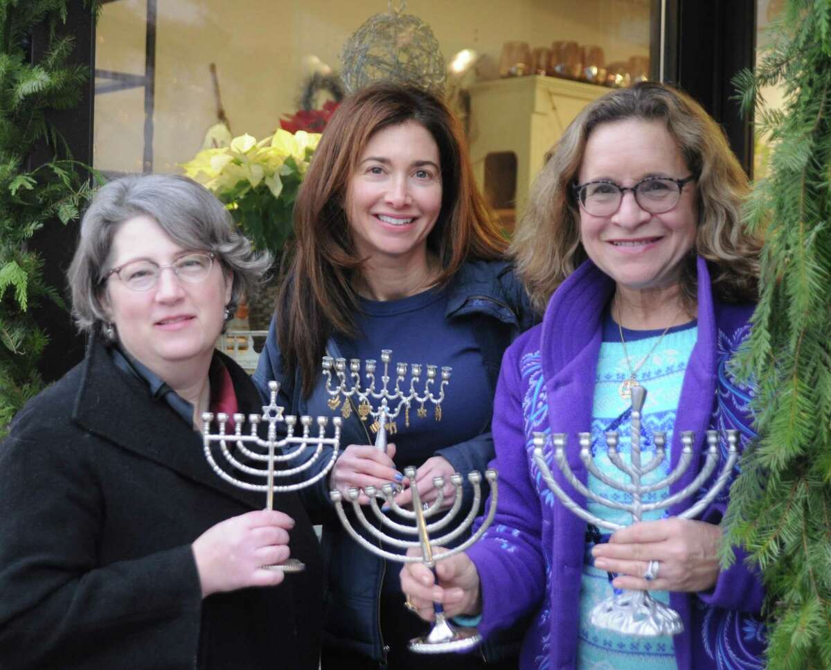Menorahs have been distributed by Deborah Katchko-Gray, cantor of Congregation Shir Shalom, to village businesses for window display during the holiday season. From left are: Mary Jones of Rodier Flowers, the president of the Downtown Ridgefield merchants association; Shir Shalom member Kimberly Knispel, and Cantor Katchko-Gray. About 35 menorahs have been distributed to business in town the last few years. Upcoming Hanukah events at Shir Shalon include: A celebration at the early childhood center at 11 a.m. on Dec. 20; a Tot Shabbat Dec. 20 at 5:30 p.m.; and a Kabbalat Shabbat for all ages on Dec. 27 at 7:30 p.m. with food and songs. p.m.