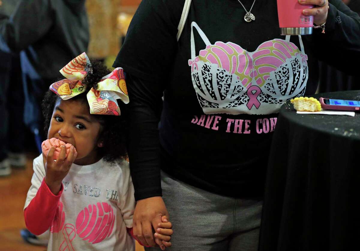 Cassandra Vega feeds her daughter Madison Vega,3. Ms Vega, a breast cancer survivor was sporting a Save the Conchas shirt with proceeds going to a battle warrior. The inaugural Concha Throwdown will be held at the Maestro Entrepreneur Entrepreneur Center Nov. 16.