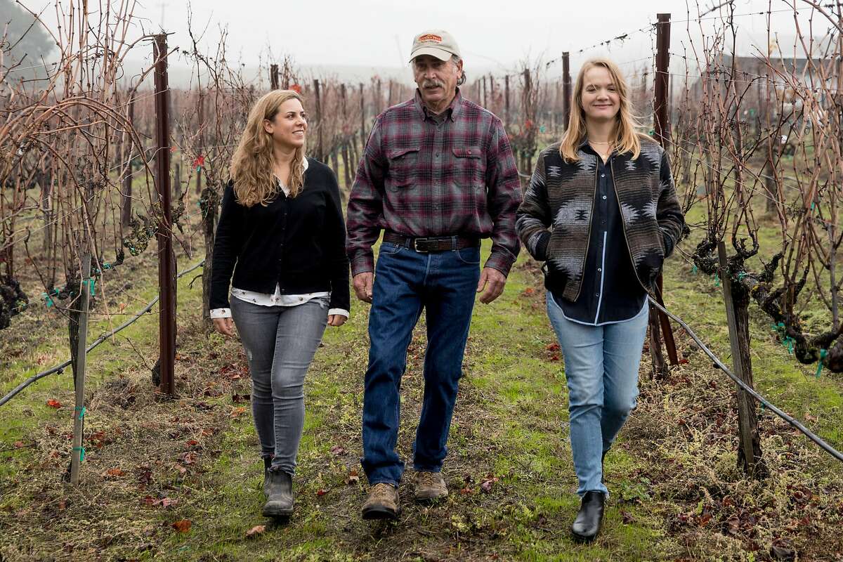 Elkhorn Peak Cellars owner Ken Nerlove (center) and his daughters and fellow Save the Family Farms members Hayley Hossfeld (right) and co-ownar Elise Nerlove chat while walking through their vineyard in Napa, Calif. Wednesday, Dec. 11, 2019.