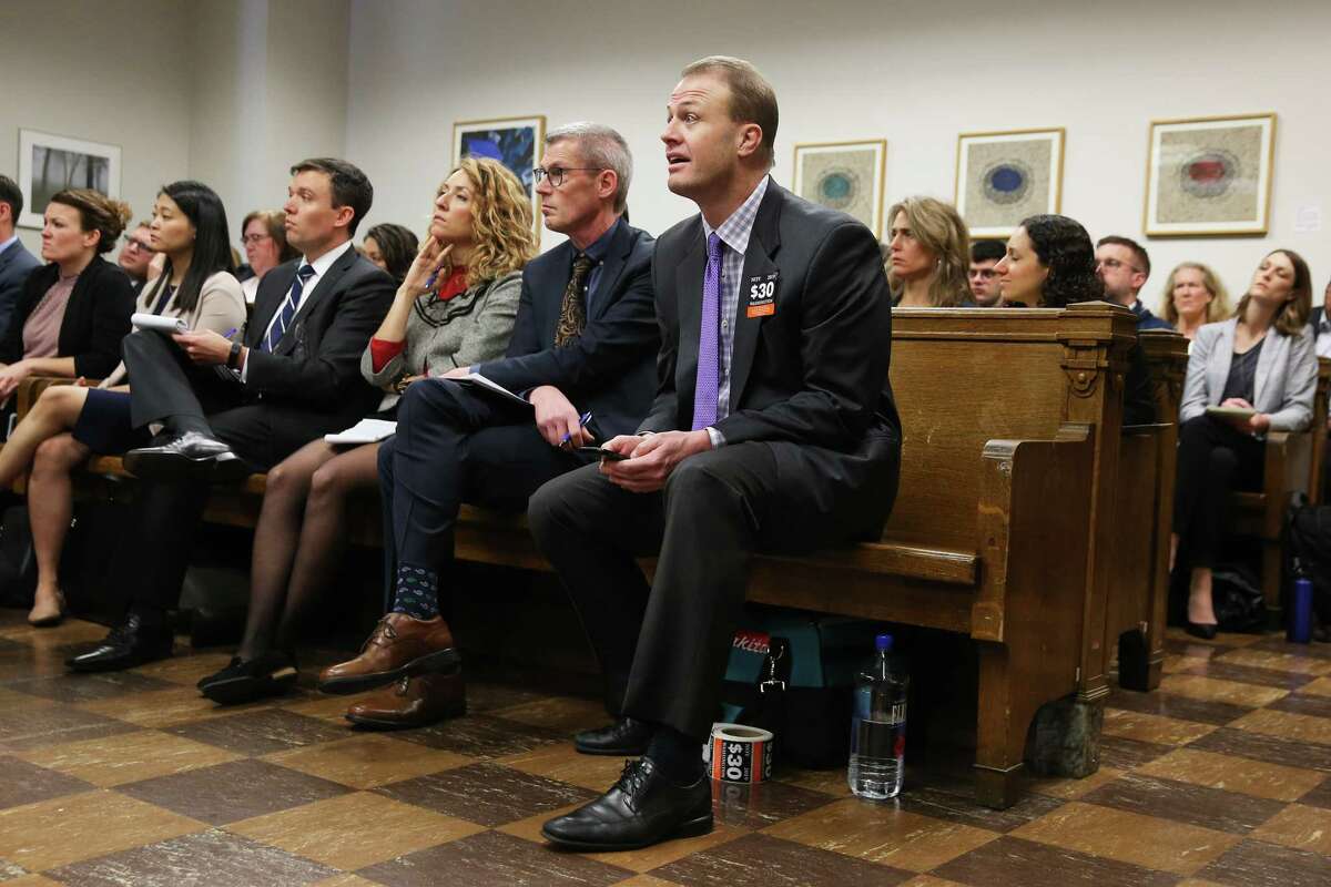 Tim Eyman, front right, listens to arguments during a hearing where a coalition of counties, transportation agencies and the city of Seattle argued in front of a King County Superior Court judge for a motion to block Eyman's Initiative 976 from taking effect Dec. 5, saying there would be irreparable harm, that it was unconstitutional and violated the single-subject rule, Tuesday, Nov. 26, 2019.