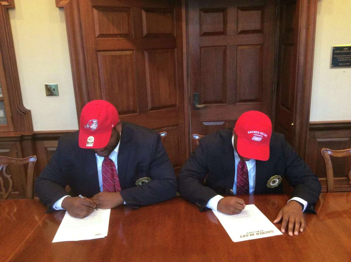 Howard Powell, left, and Jalen Madison each signed National Letters of Intent to play football at Sacred Heart University.