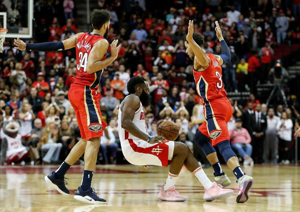HOUSTON, TX - OCTOBER 26: James Harden #13 of the Houston Rockets loses control of the ball defended by Josh Hart #3 of the New Orleans Pelicans and Kenrich Williams #34 in the fourth quarter at Toyota Center on October 26, 2019 in Houston, Texas. NOTE