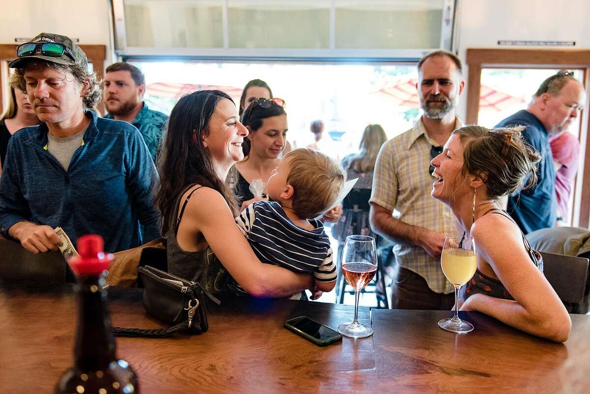 People mingle at the bar inside the Tasting Barn at Horse & Plow Winery in Sebastopol, Calif., on Friday June 1, 2018.