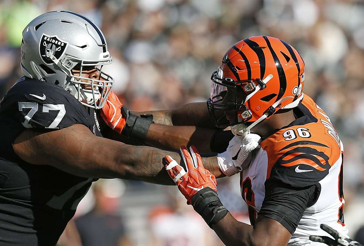 FILE - In this Nov. 17, 2019, file photo, Oakland Raiders offensive tackle Trent Brown (77) blocks Cincinnati Bengals defensive end Carlos Dunlap (96) during the first half of an NFL football game in Oakland, Calif. The Raiders placed Brown on season-ending injured reserve, one day after the big right tackle was named to his first Pro Bowl. Brown, who this past offseason signed a contract making him the highest-paid offensive lineman in NFL history, has missed the past two games because of a pectoral injury after sitting out one game earlier in the season with an ankle injury. “His pec is just not getting any better,” Raiders coach Jon Gruden said Wednesday, Dec. 18. “It’s disappointing. Obviously what he did put on tape was very impressive.” (AP Photo/D. Ross Cameron, File)