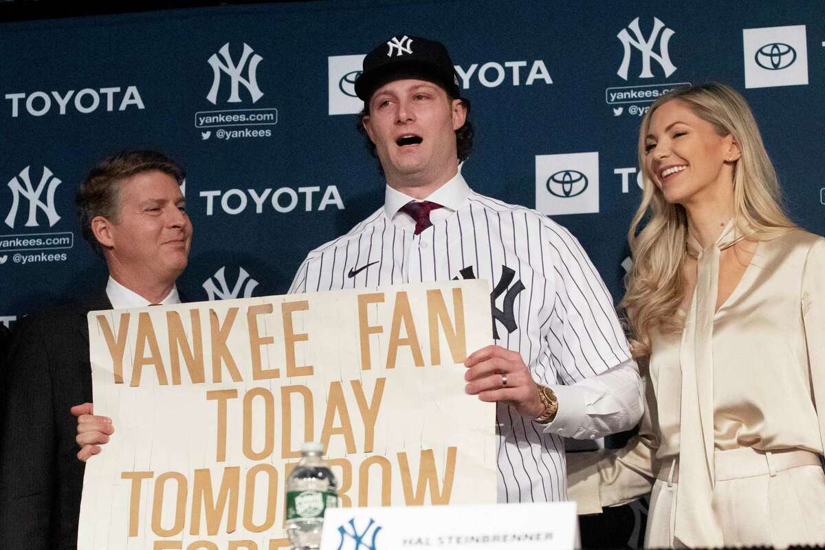 Yankees pitcher Gerrit Cole, center, holds a sign he used as a young Yankees fan, as he is introduced by the team on Wednesday.