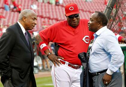 Cincinnati Reds manager Dusty Baker, center, talks with Hall of Fame players Frank Robinson, left, and Joe Morgan before Game 3 of the National League Division Series baseball game against the Philadelphia Phillies Sunday, Oct. 10, 2010, in Cincinnati. (AP Photo/Gene J. Puskar)