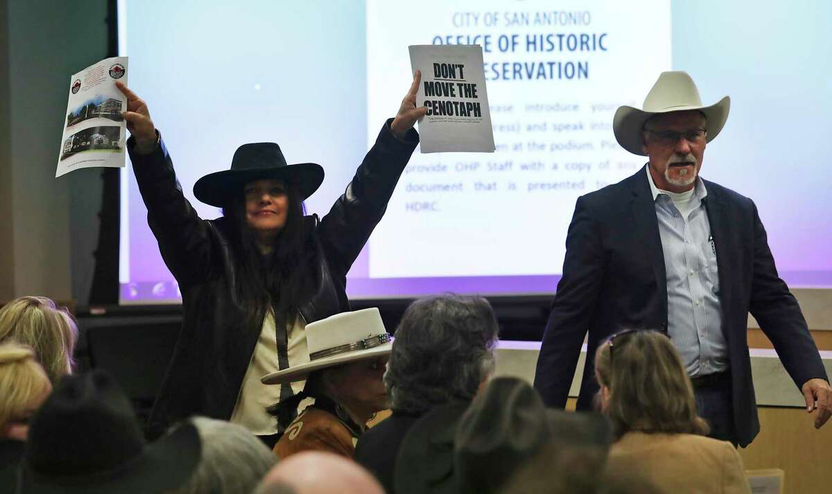 Maria Torres, Chairwoman of the Pacuache Indian First Nation holds up signs as citizens concerned with the new plans for the Alamo speak for and against the plans at a meeting of the city Historic and Design Review Commission at the Development and Business Services Center in San Antonio on Wednesday, Dec. 18, 2019.