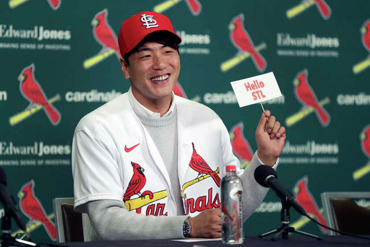 Cardinals pitcher Kwang-Hyun Kim smiles as he holds up a sign during a news conference Tuesday in St. Louis. The Cardinals have signed the Korean left-hander to a two-year contract.