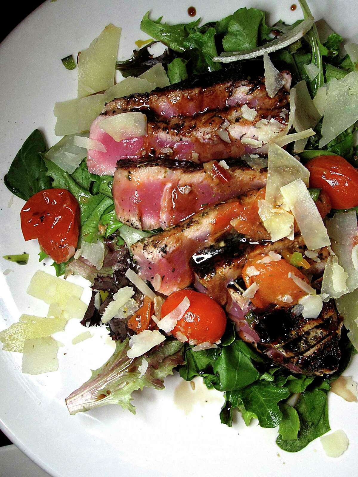 A pepper-crusted ahi tuna salad comes with avocado, tomato and honey soy vinaigrette at Iron Stag.