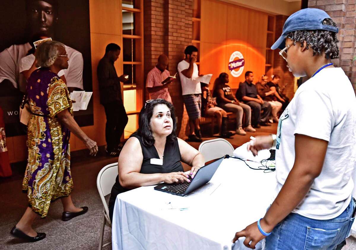 Ilsa Nieves of the American Job Center Workforce Alliance, left, pre-registers people for interviews for approximately 1800 Amazon North Haven warehouse facility openings during a job fair in New Haven, Conn., on Aug. 30, 2019. Connecticut has gained 13,300 jobs in the past year, including 4,000 in February 2020.