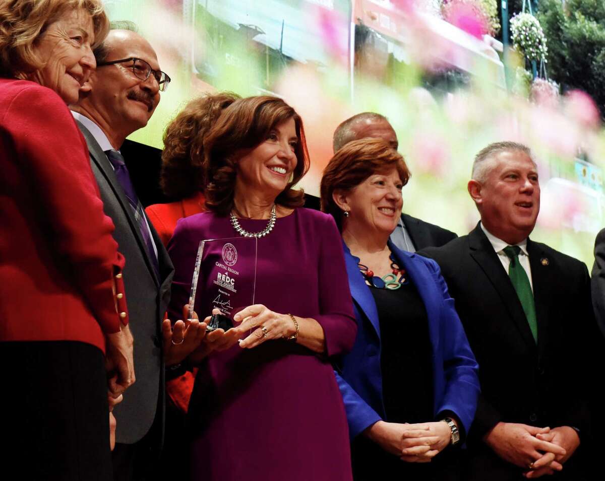 Sen. Betty Little, left, University at Albany President Havidán Rodríguez, Mayor Kathy Sheehan, second from right, and Assemblyman John T. McDonald III, right, and other Capital Region representatives, pose for a photo with Lt. Gov. Kathy Hochul, center, after the district was awarded $84.1 million by the state for economic development on Thursday, Dec. 19, 2019, during the Regional Economic Development Council awards ceremony at the Capital Center in Albany, N.Y. (Will Waldron/Times Union)