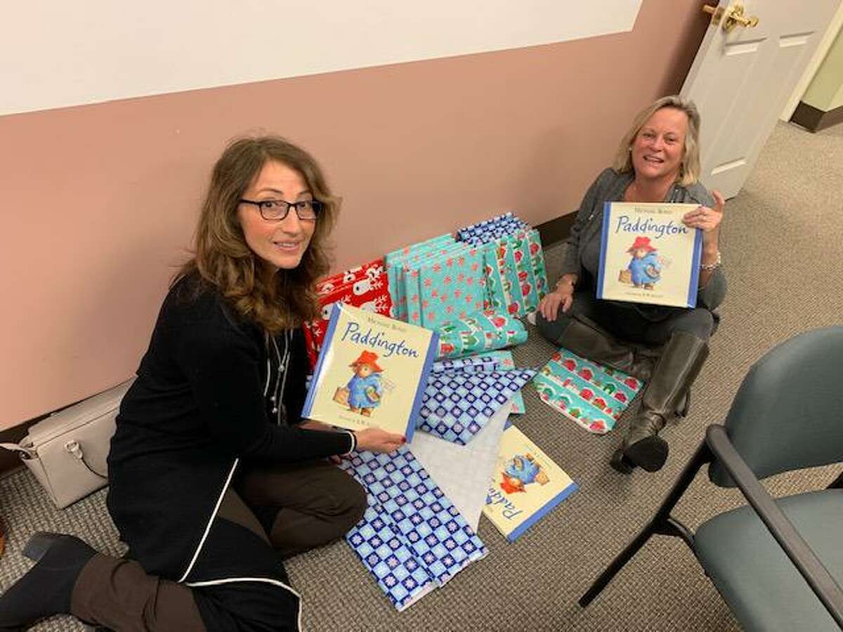 Ridgefield realtors Toni Riordan, left and Mary Pat Sexton, right spent time at the CT Coalition to End Homelessness office in Hartford last week wrapping Paddington bears, books and blankies that were delivered to children living in shelters across Connecticut for the holidays.