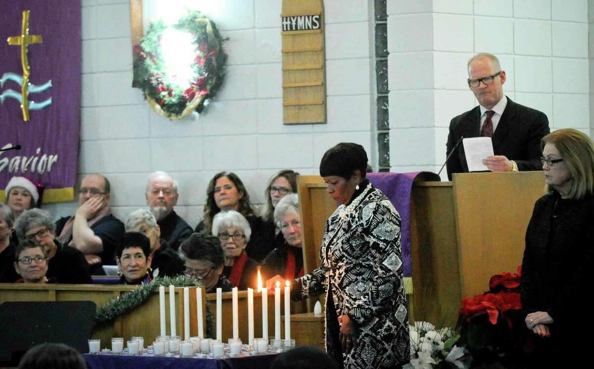 Denise Durham Williams, CEO of Inspirica, lights a candle during a Homeless Persons' Memorial Service at the Bethel AME Church in Stamford, Conn. on Dec. 19, 2019. Several local clergy, community agencies, city and state leaders, along with residents joined together in Darkness to Light, lighting candles as they remember those forgotten and those working to end homelessness on National Homeless Persons' Memorial Day.