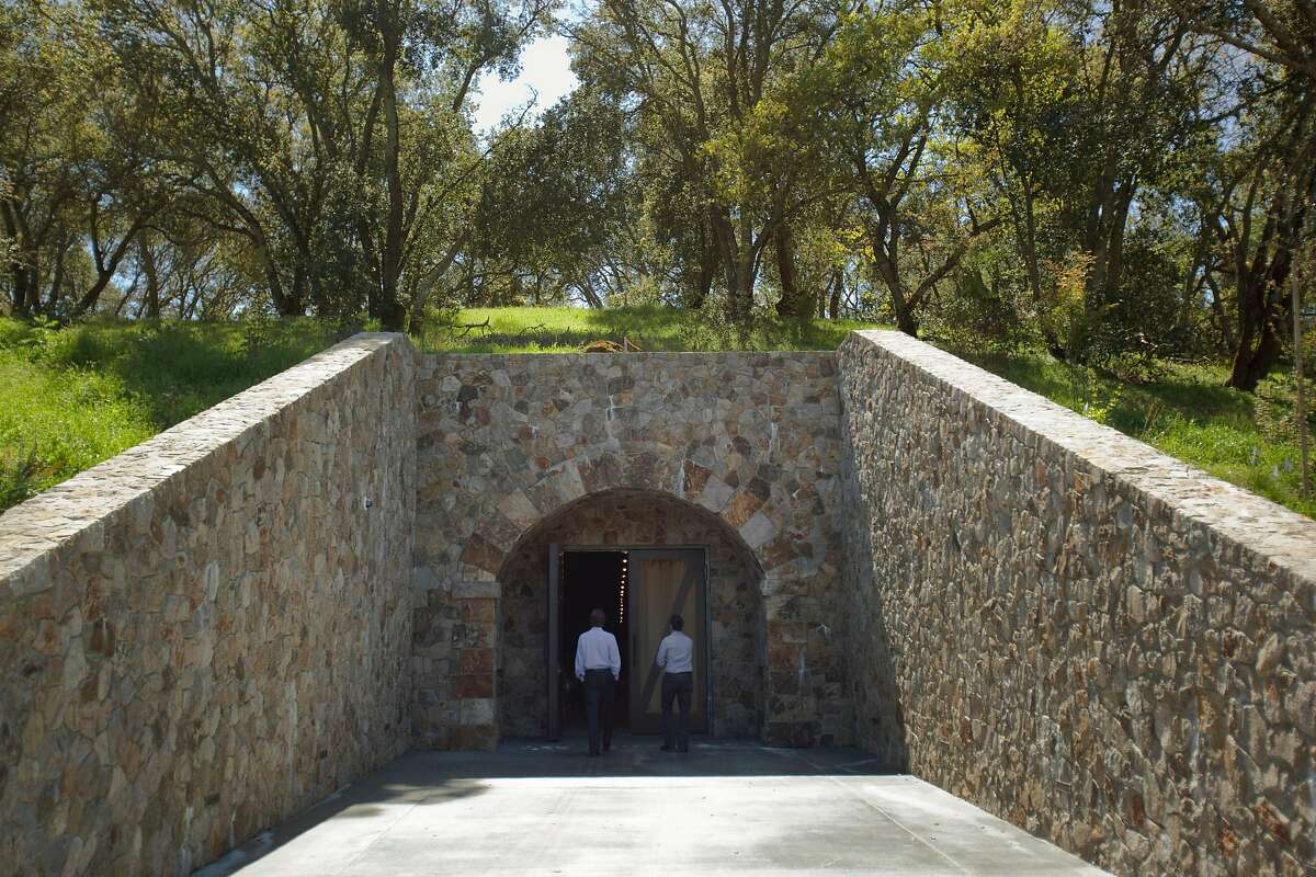 People walk into the entrance of a wine cave at the Kenzo Estate winery in Napa, California, U.S., on Wednesday, April 7, 2010. Kenzo Tsujimoto, chairman of Japan's Capcom Group, established a presence in Napa Valley in the nineties, with the acquisition of several thousand acres on the slopes of St. George. Photographer: Kim White/BloombergEDITOR'S NOTE: IMAGES EMBARGOED UNTIL 00:01 MAY 1, 2010.