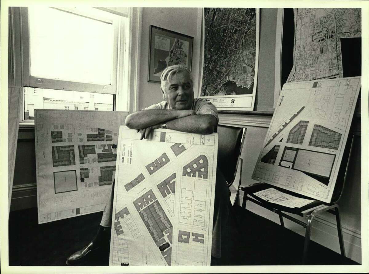 Ed Logue poses in his South Bronx office in the 1980s, surrounded by graphic evidence of development plans for the beleaguered New York City community.
