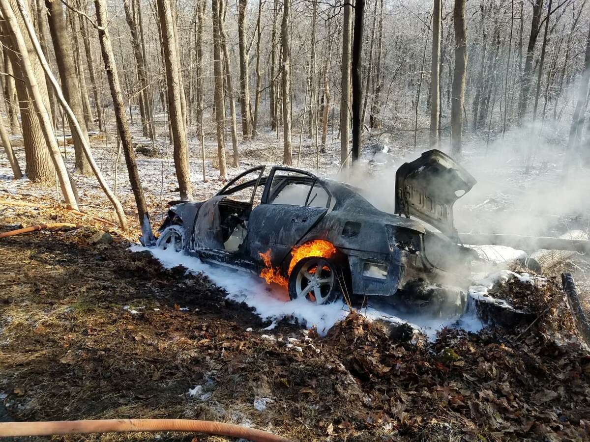Flames come of this vehicle that caught fire on Rosebrook Road in New Canaan, Connecticut, Thursday morning, Dec. 19, 2019, with the driver's life saved.