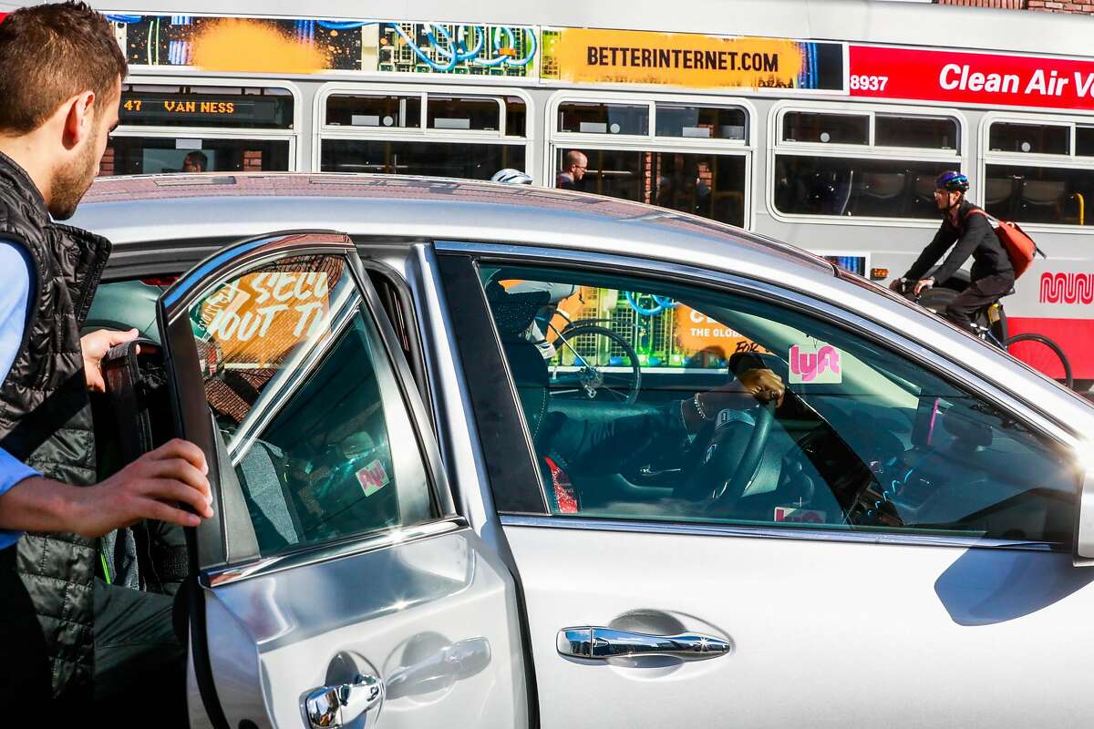 A man hops into a Lyft car outside the Cal Train station on Townsend Street in San Francisco, California, on Monday, May 20, 2019. Both Uber and Lyft have agreed to a 3.25%-per ride tax in an effort to avoid a tax on their gross receipts. The taxes will generate an estimated $30 million to $35 million for transportation improvements and street-safety upgrades.