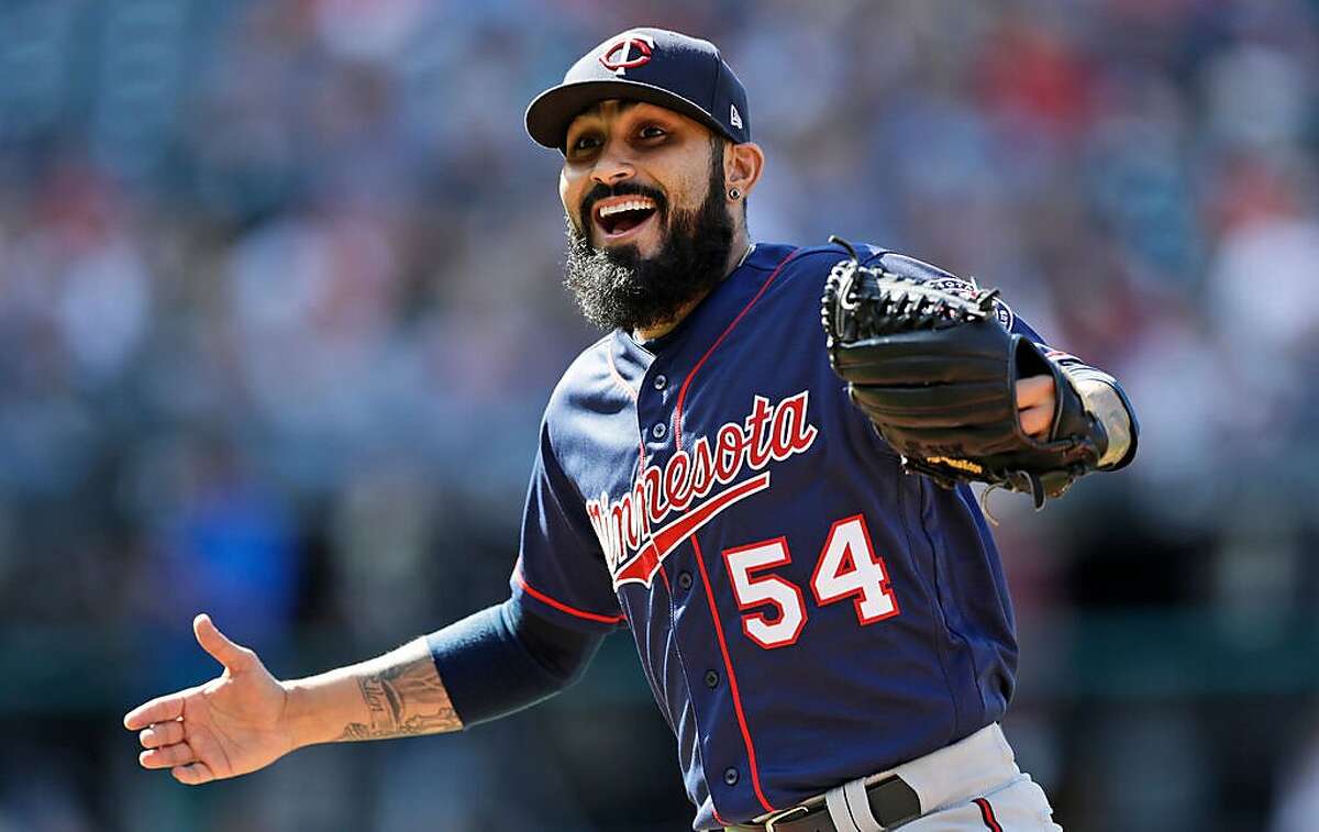 FILE - In this Sept. 14, 2019, file photo, Minnesota Twins relief pitcher Sergio Romo walks back to the dugout with a smile during a baseball game against the Cleveland Indians in Cleveland. The Twins have signed two veteran right-handed relievers, Sergio Romo and Tyler Clippard. Romo joined the team last July in a trade with San Francisco. (AP Photo/Tony Dejak, File)