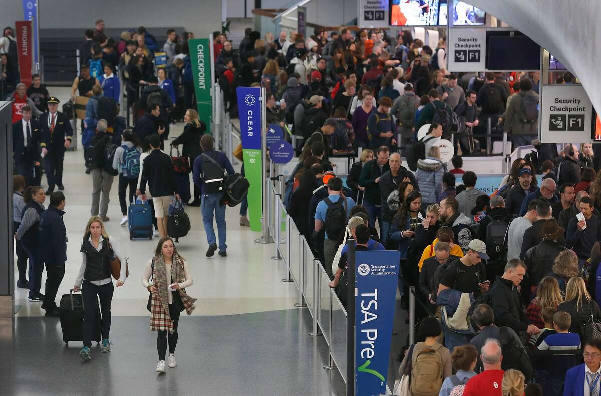 Holiday air travelers wait to pass through security screening in Terminal 3 at SFO in San Francisco, Calif. on Friday, Dec. 20, 2019. Conditions may worsen in the coming days as a rainstorm scheduled to hit the area over the weekend could snarl holiday travel plans.